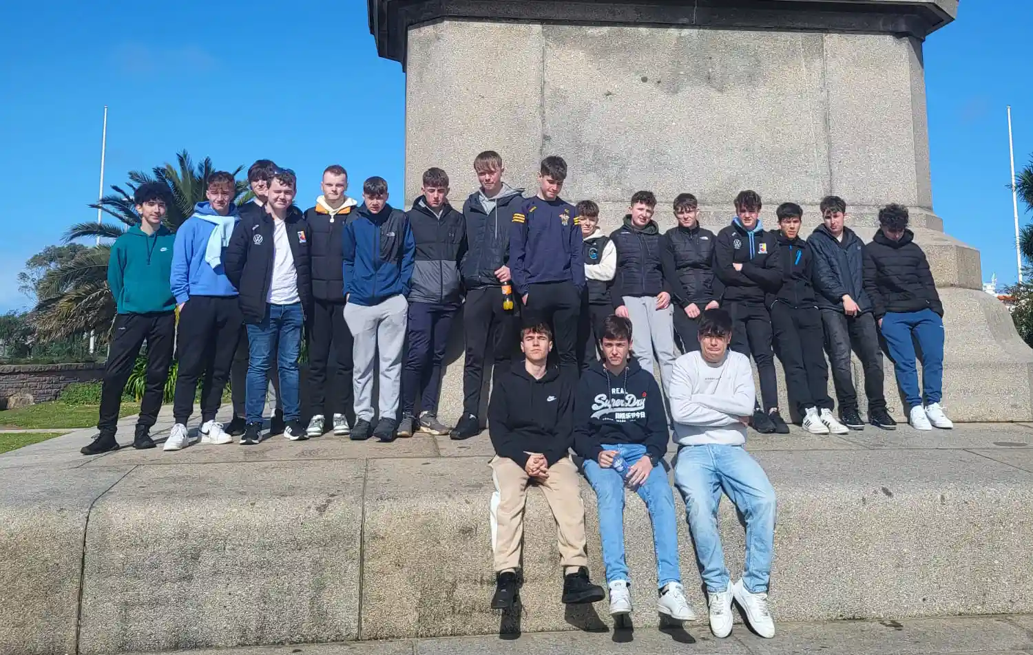 Boys standing in front of statue of a horse on French Tour to Normandy