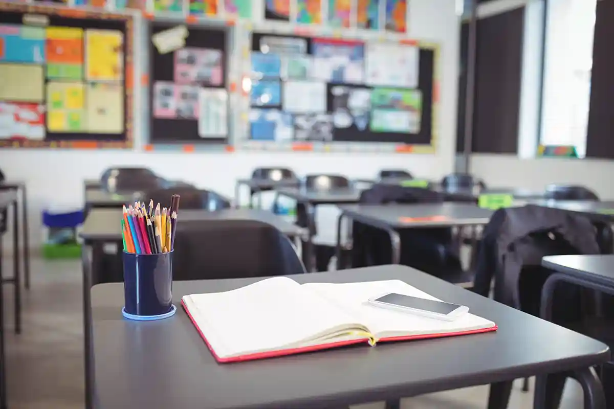 empty school classroom with school supplies on desk