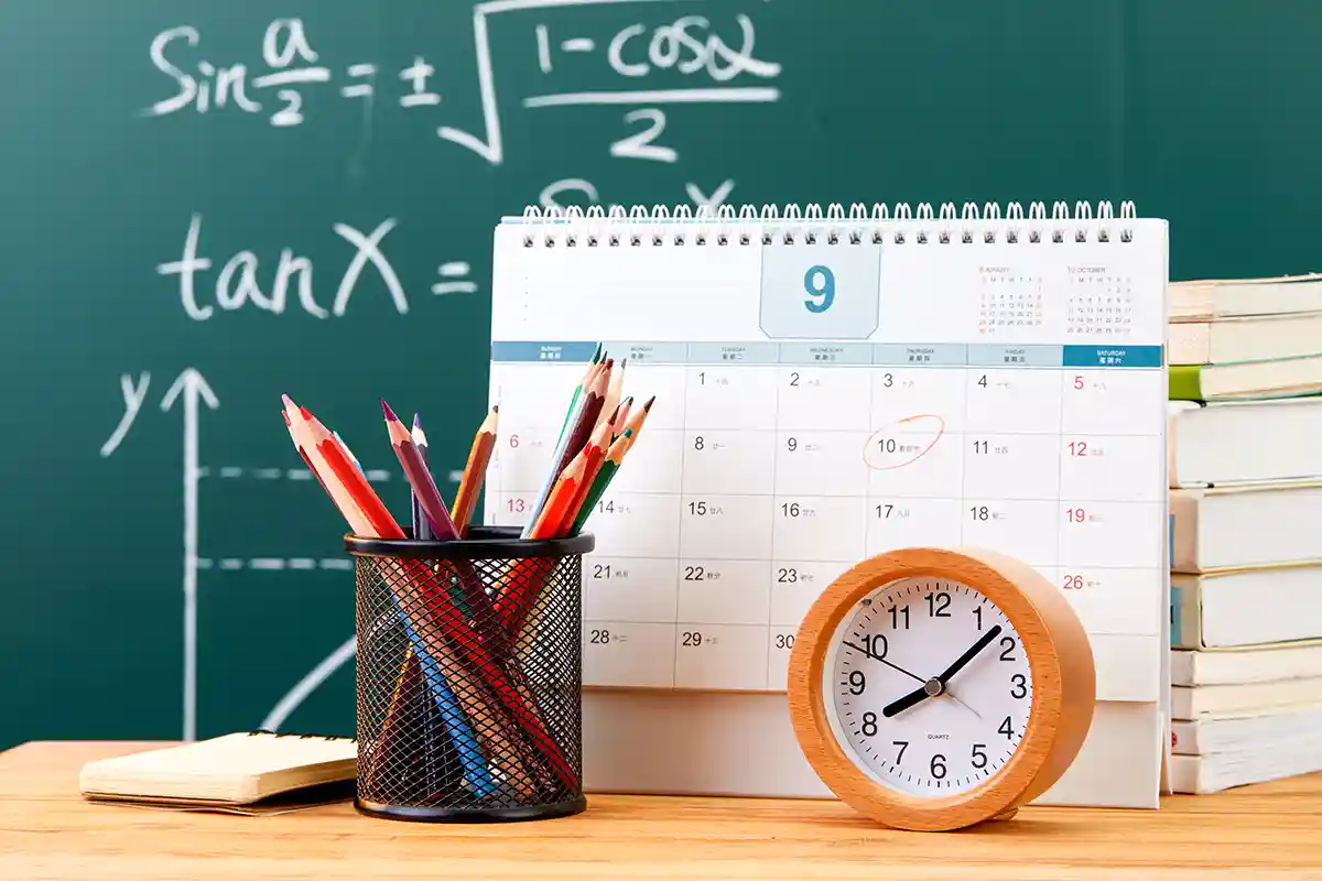 math formulas on a chalkboard with school supplies